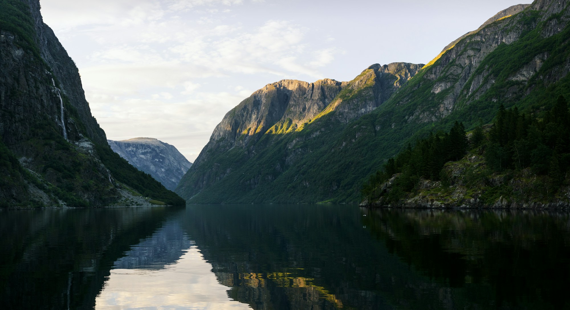 Steep green mountains and open water at Geirangerfjord, Norway